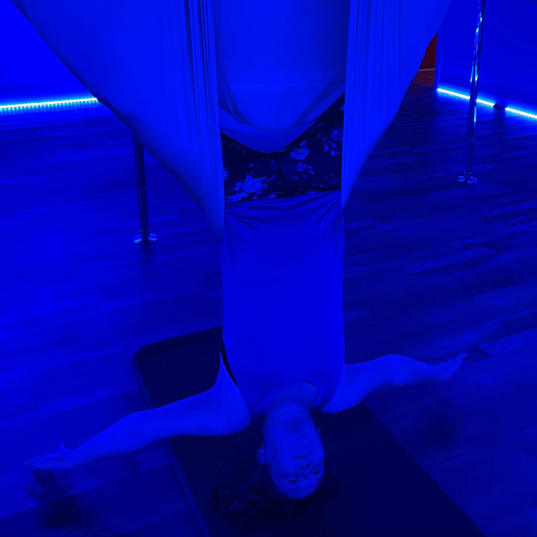 Allison P demonstrates an invert in the aerial yoga hammock